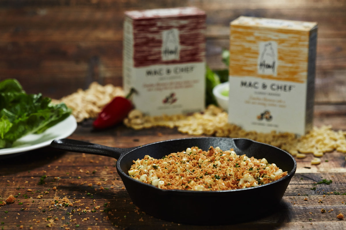 Skillet filled with Vegan Mac and Cheese in front of Howl Mac & Chef cartons